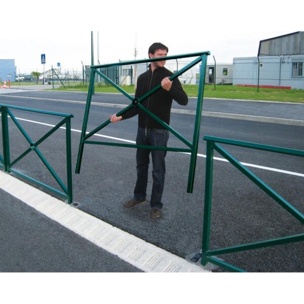 Photo illustrative d'un homme posant une barrière de sécurité vert 6005 au bord d'une route