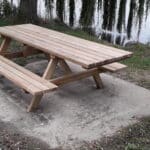 Photo d'une table de pique nique en bois monobloc au près d'un point d'eau