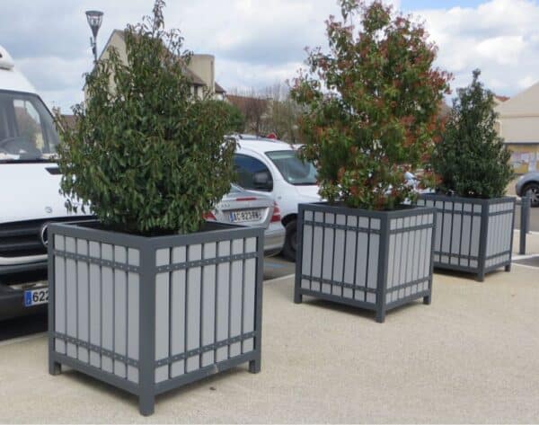 Photo de 3 bacs à fleurs suzon sur une place au bord d'un parking