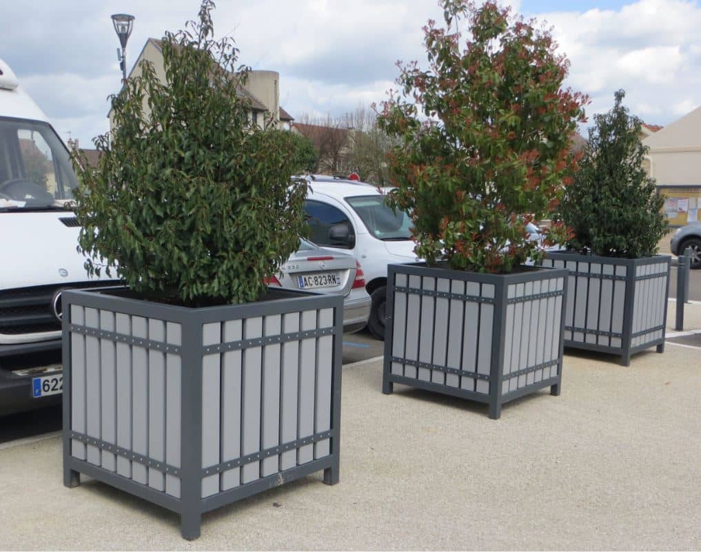Photo de 3 bacs à fleurs suzon sur une place au bord d'un parking