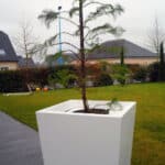 Photo d'un pot de fleurs composite terou blanc sur une terrasse