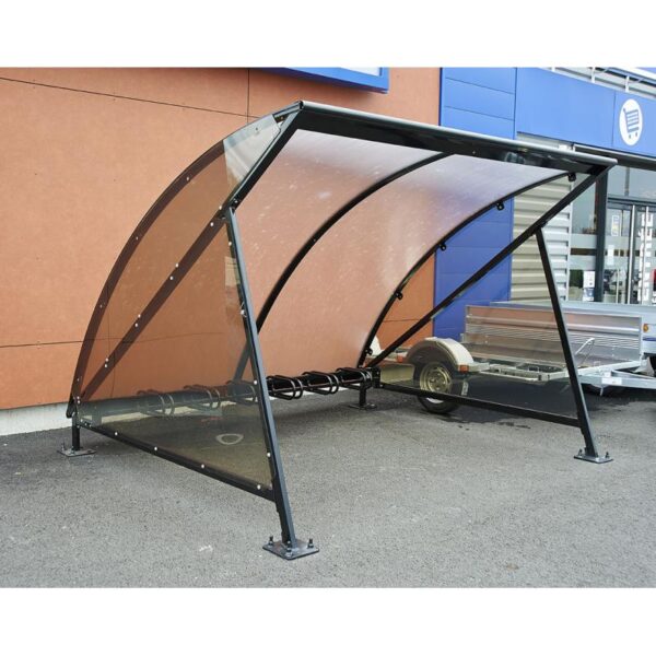 Photo d'un abri vélos demi-lune noir avec un support vélo 6 places devant un magasin