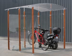 Photo d'un vélo et d'un scooter accrochés à un rack en acier galvanisé, sous un abri vélos bois