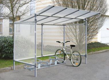 Photo d'un vélo gris accroché à un support vélos emplacements décalés galva 6 places sous un abri vélos