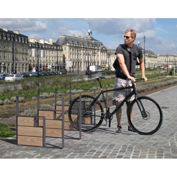 Photo d'un homme utilisant un appui vélos kub acier gris et bois