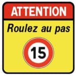 Illustration d'un panneau spécial en aluminium "ATTENTION Roulez au pas" et indiquant une limitation de vitesse à 15km/h