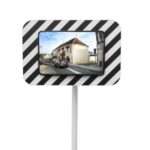 Illustration d'un miroir routier rectangulaire économique à bords noirs et blancs sur poteau