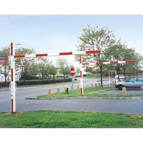 Photo de deux demi portiques universels tournants rouges et blancs ouverts à l'entrée d'un parking