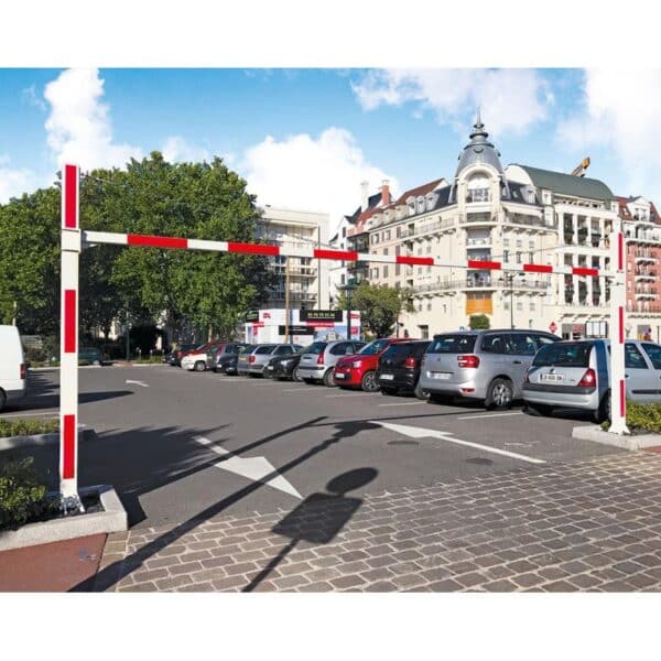 Photo d'un portique universel fixe rouge et blanc à l'entrée d'un parking rempli de voitures