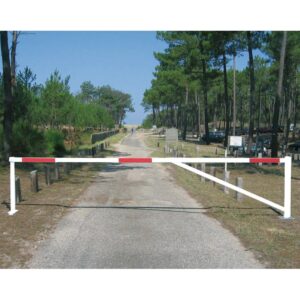 Photo d'une barrière universelle tournante rouge et blanche fermée à l'entrée d'un chemin