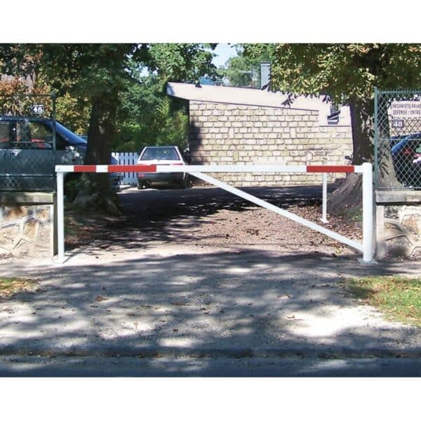 Photo d'une barrière universelle tournante rouge et blanche fermée à l'entré d'un parking d'une propriété privée