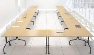 Photo d'une salle de conférence pleine de tables avec plateaux rabattables dans une salle de conférence