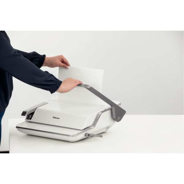 Photo d'une personne reliant des feuilles avec un perforelieur 3 en 1