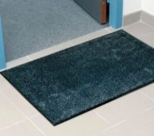 Photo d'un tapis très doux microfibres d'intérieur gris au pied d'une porte ouverte
