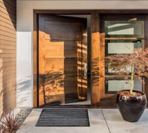 Photo d'un tapis grattant pro extérieur gris au pied d'une porte d'entrée ouverte