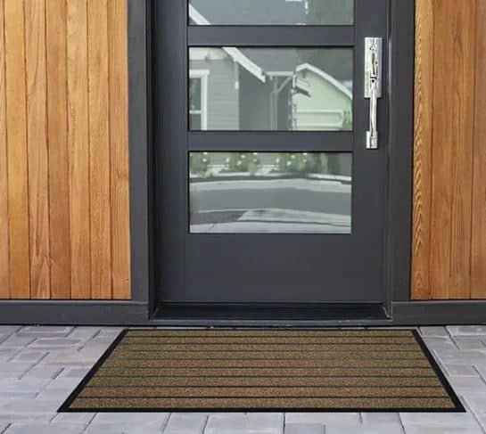 Photo d'un tapis grattant pro extérieur marron au pied d'une porte d'entrée