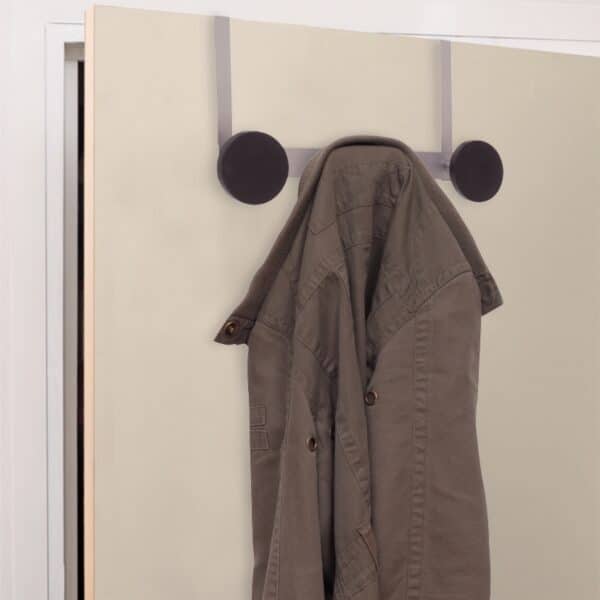 Photo d'une veste sur une patère grand diamètre en plastique noir avec finition en époxy gris aluminium 3 patères sur une porte beige