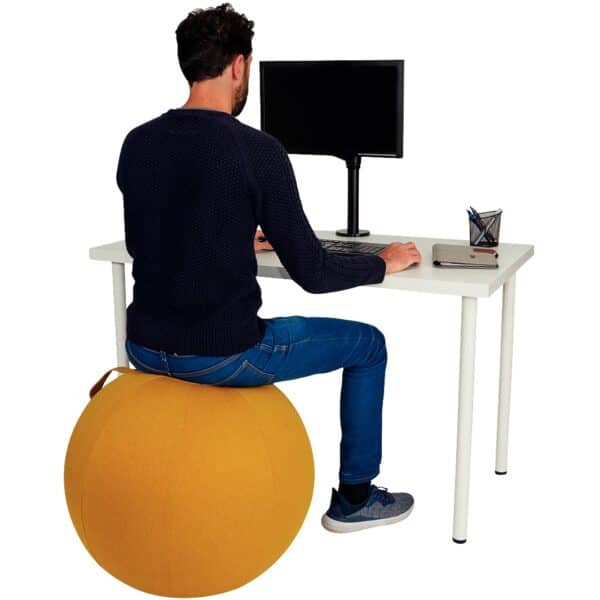 Photo d'un homme sur un ballon d'assise ergonomique jaune