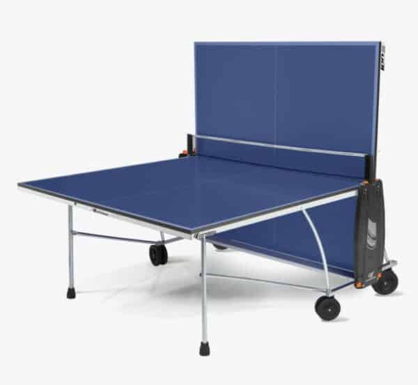 Photo d'une table de ping-pong d'intérieur bleue repliée du côté gauche