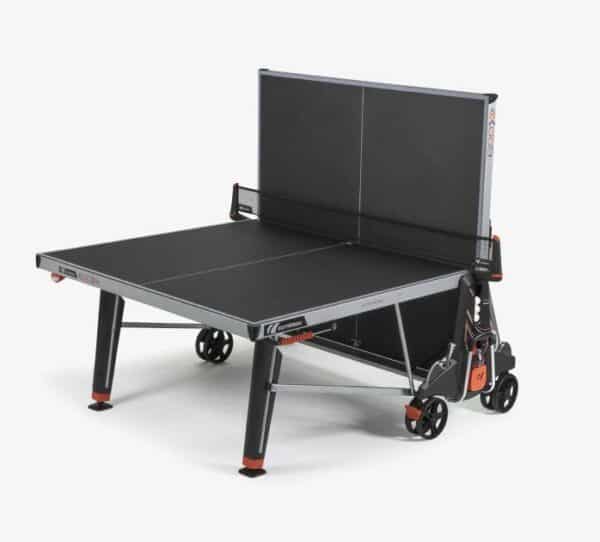 Photo d'une table de ping-pong d'intérieur repliée du côté gauche