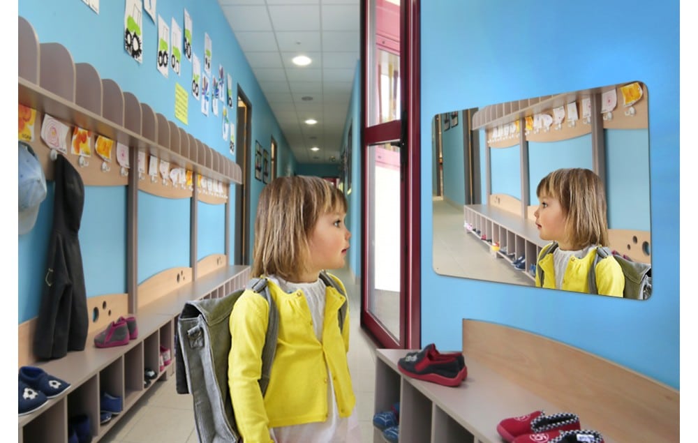 Photo d'une enfant se regardant dans un miroir plat pour sanitaire