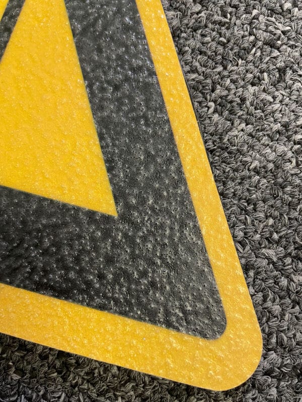 Photo gros plan sur un pictogramme préfabriqué résine adhésif triangulaire jaune