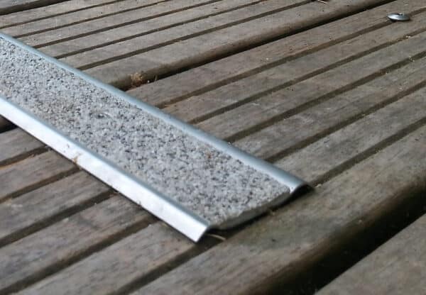 Gros plan d'un nez de marche en inox à visser sur une passerelle