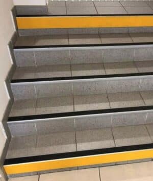 Photo de contremarches adhésives jaunes en haut et en bas d'un escalier