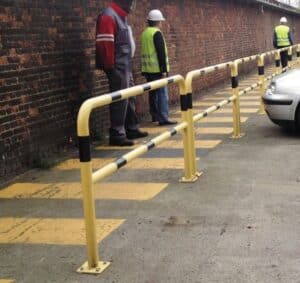 Photo de barrières de protection à fixer jaunes à bandes noires le long d'un passage piéton