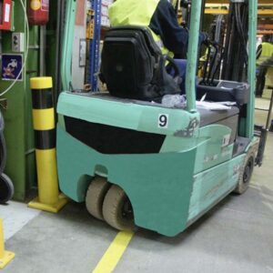 Photo d'un chariot élévateur touchant un poteau de protection en polyuréthane jaune et noir dans un espace de production