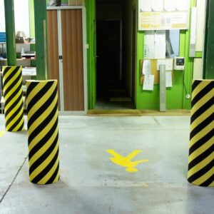 Photo de protections industrielles en mousse à bandes jaunes et noires dans un espace de production