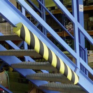 Photo d'une protection d'arrête en mousse à bandes jaunes et noires sous un escalier en métal bleu