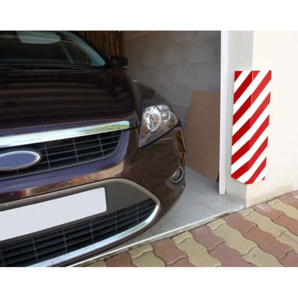 Photo d'une protection d'angle en mousse à bandes rouges et blanches à l'entrée d'un garage