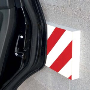 Photo d'une portière de voiture touchant une protection murale à bandes rouges et blanches