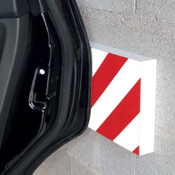 Photo d'une portière de voiture touchant une protection murale à bandes rouges et blanches