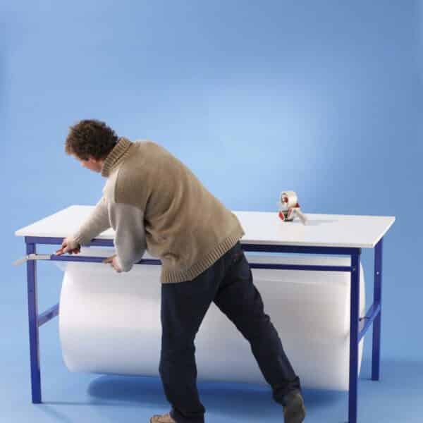 Photo d'un homme utilisant une table simple d'emballage