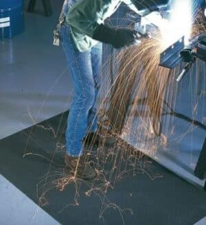 Photo d'un soudeur travaillant debout sur un tapis antifatigue spécial soudeur