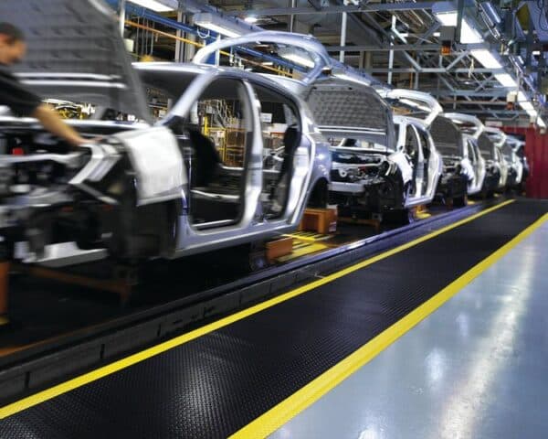 Photo de tapis antifatigue haute performance noirs et jaunes sur un site de production automobile