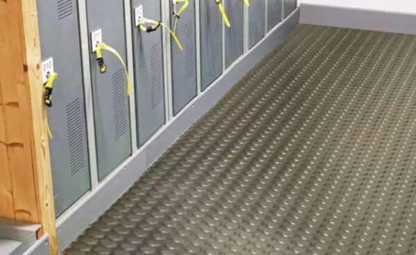 Photo de tapis pastillés en rouleau gris appliqué à un sol de vestiaire
