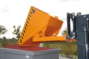 Photo d'une benne basculante type expo orange soulevée et basculée par un chariot élévateur