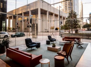 Photo d'un espace de détente au rez-de-chaussée d'un immeuble vitré, avec vue sur une rue d'un quartier moderne