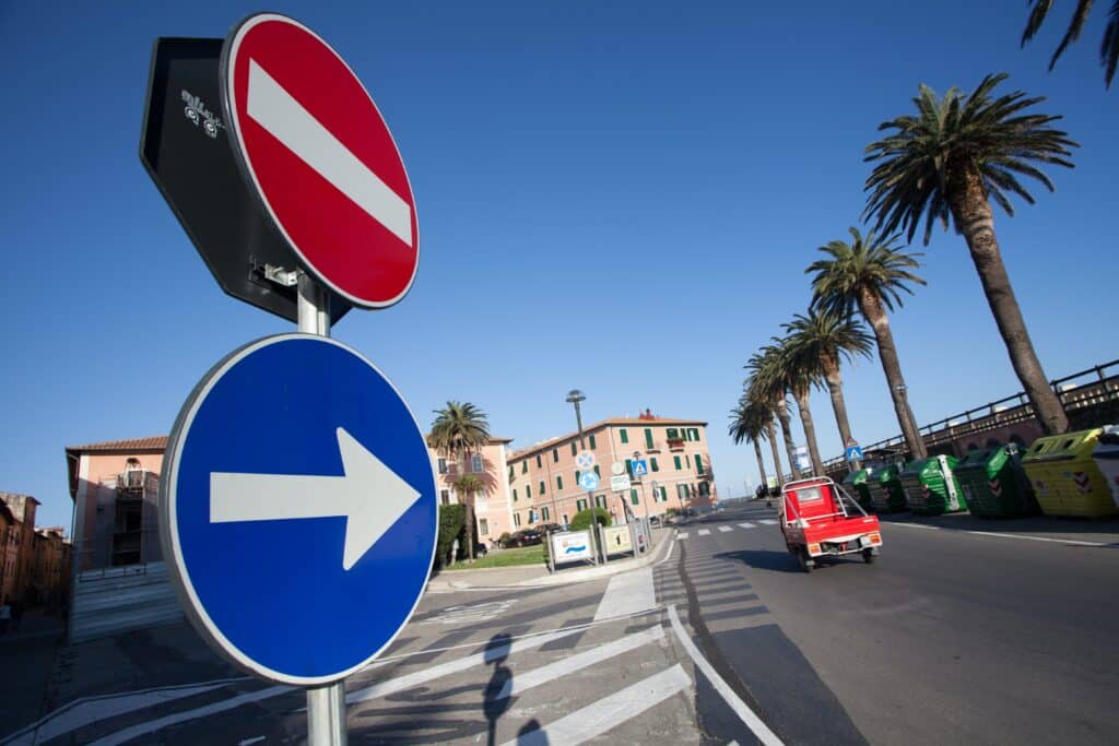 Photo illustrative d'un poteau rond avec deux panneaux : un sens interdit et une obligation de tourner à droite