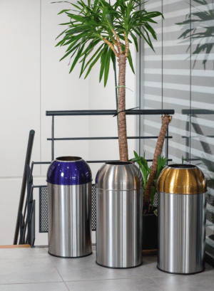 Photo de trois collecteurs de tri 40l avec couvercle inox, inox bleu et inox jaune dans une en haut d'un escalier - probbax