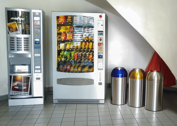 Photo de trois collecteurs de tri 40l avec couvercle inox, inox bleu et inox jaune dans une salle de pause- probbax